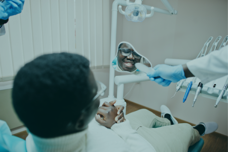 paciente-de-homem-afro-americano-na-cadeira-odontologica-escritorio-de-dentista-e-conceito-de-pratica-medica-dentista-profissional-ajudando-seu-paciente-na-odontologia-medica-e-mostrando-a-ele-um-espelho